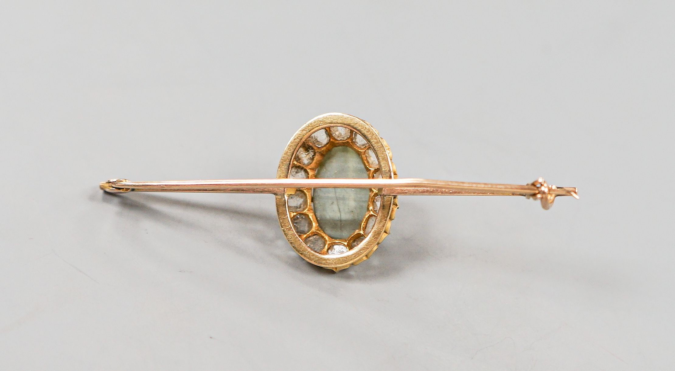 A yellow metal cat's eye chrysoberyl and rose cut diamond set bar brooch, 62mm, gross weight 6 grams.